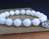Energy Bracelet - Opaque White Shell Beads & Tierra Cast Pewter Om (Aum) Charm - by We Are 1