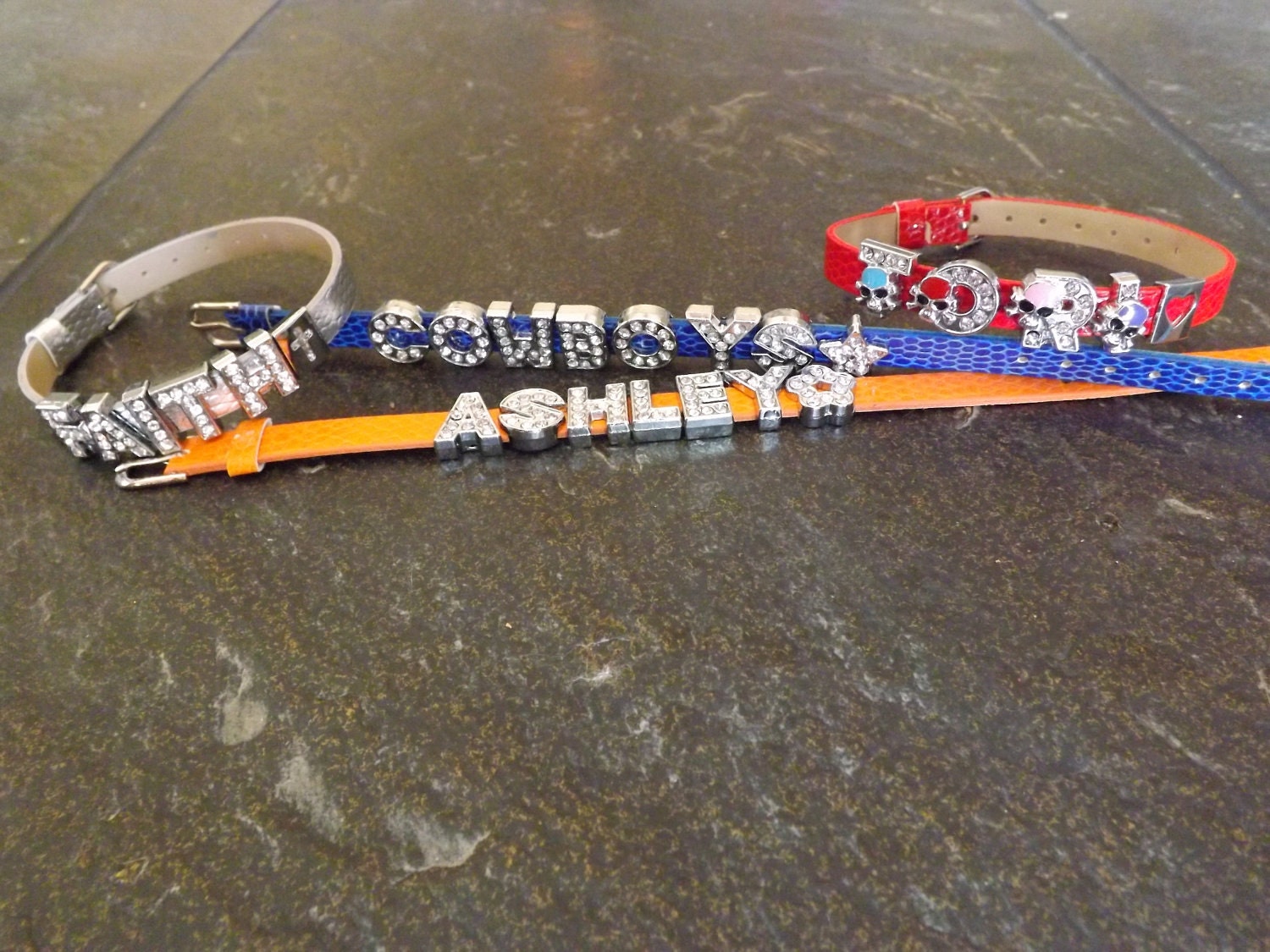 Trendy personalized rhinestone slider bracelet on a leather look strap.