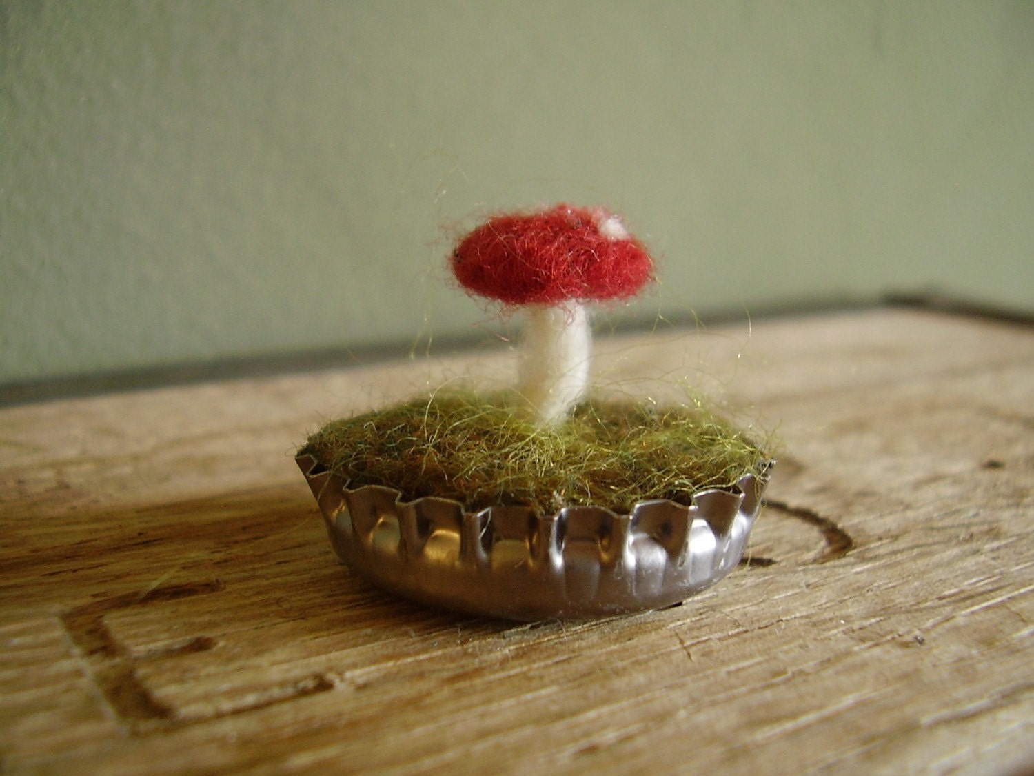 Felted red amanita mushroom in a silver bottlecap