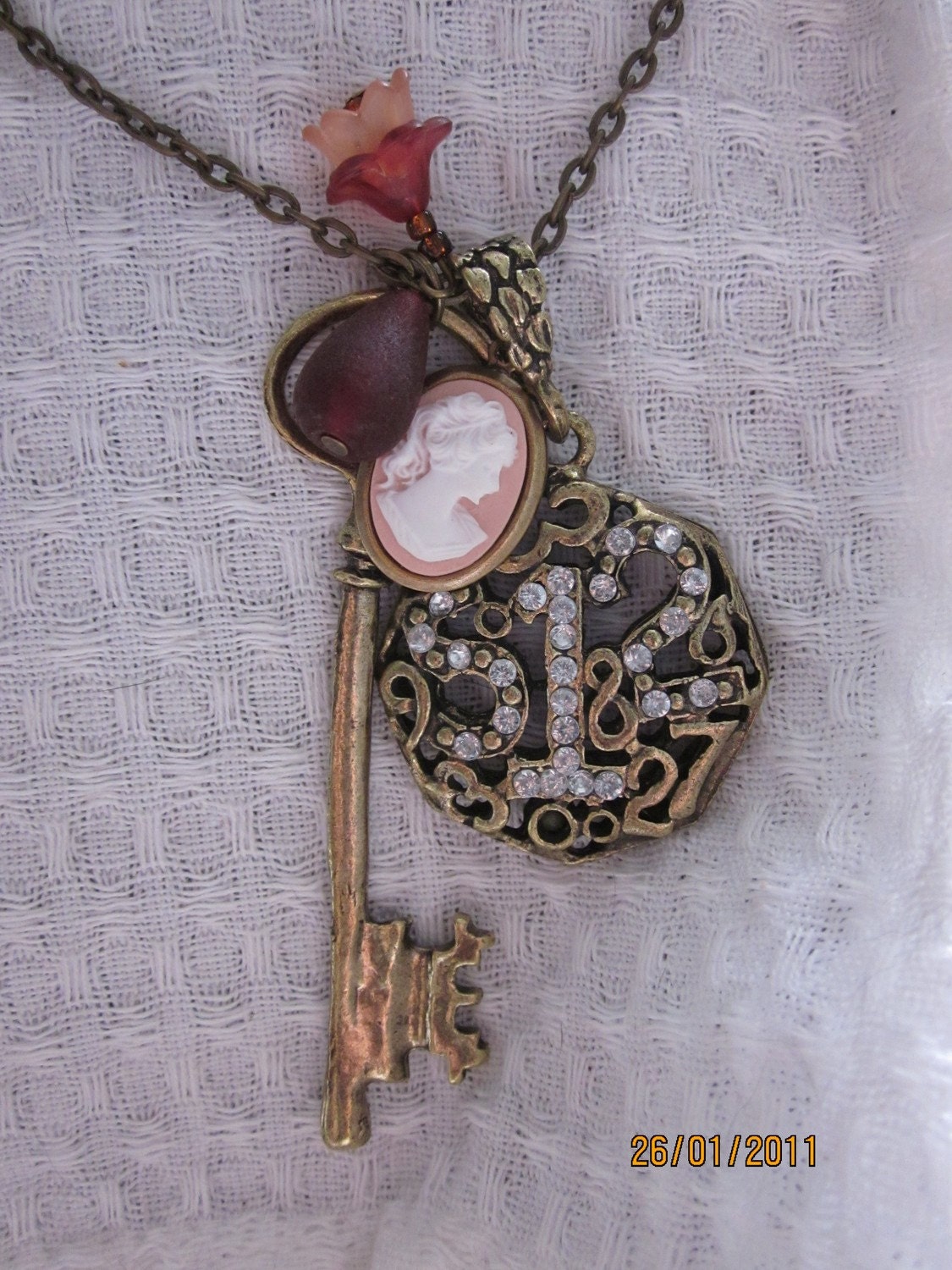 Antique brass metal necklace with vintage key, number charm and classic cameo