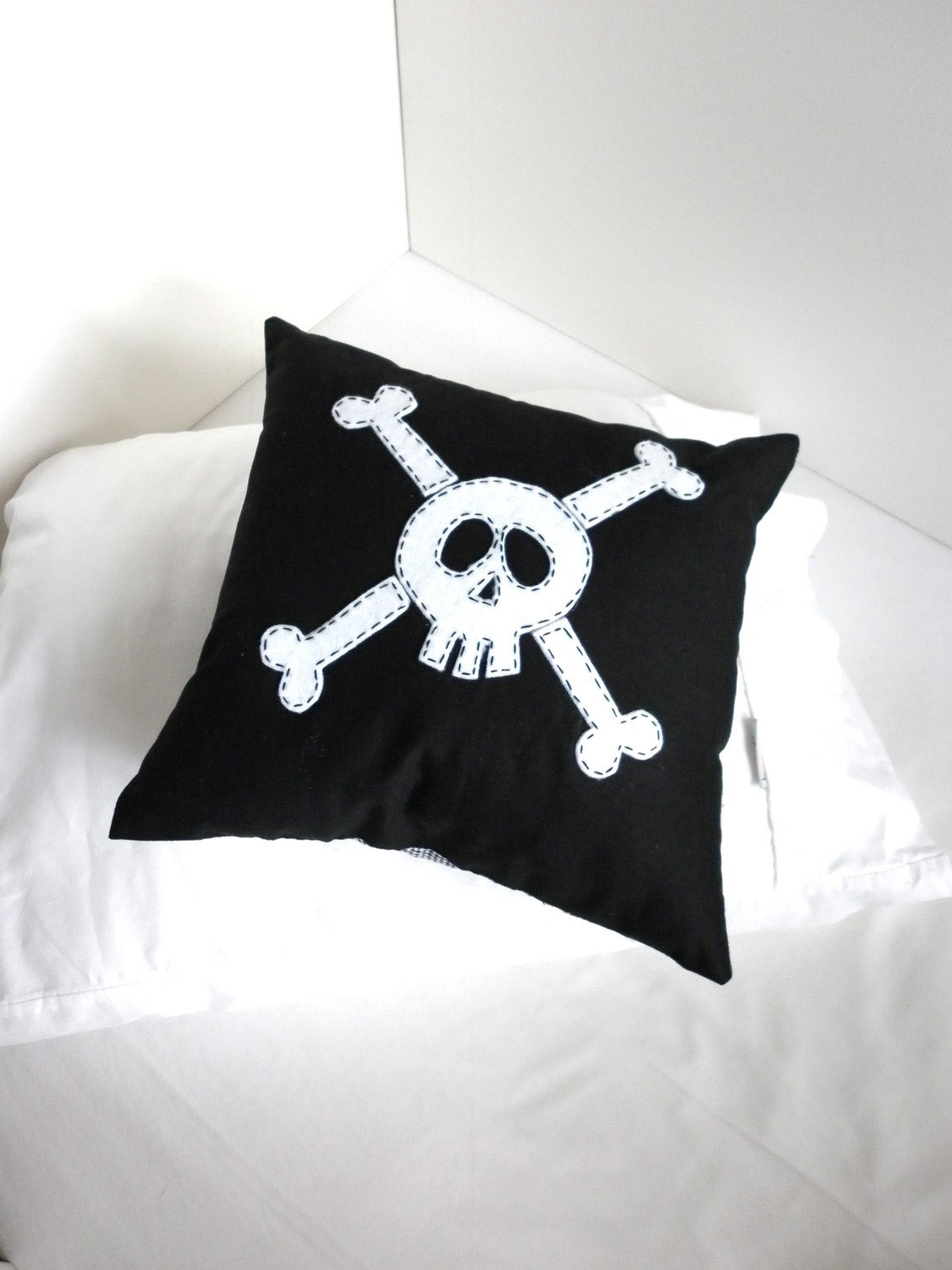 Black Skull and Crossbone cushion cover in small.
