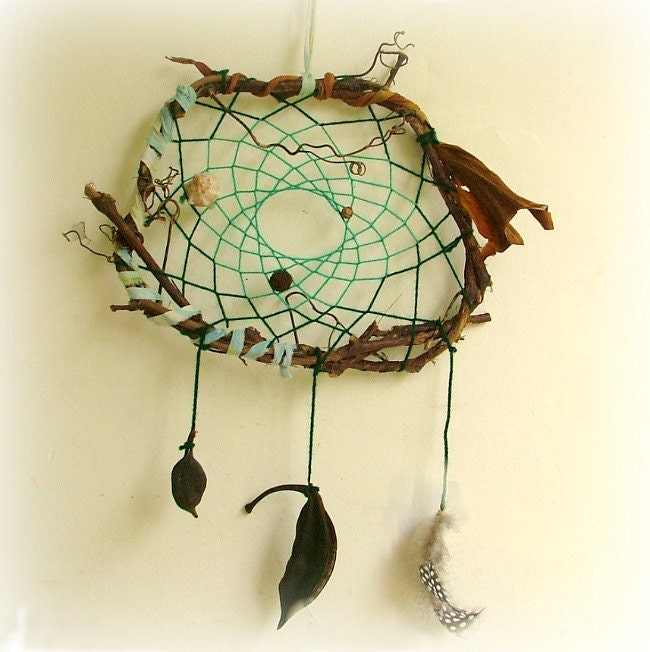Baby mobile earth art magical dream catcher weaved in 2 shades of green with black pods and spotted feathers.