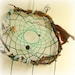 Baby mobile earth art magical dream catcher weaved in 2 shades of green with black pods and spotted feathers.