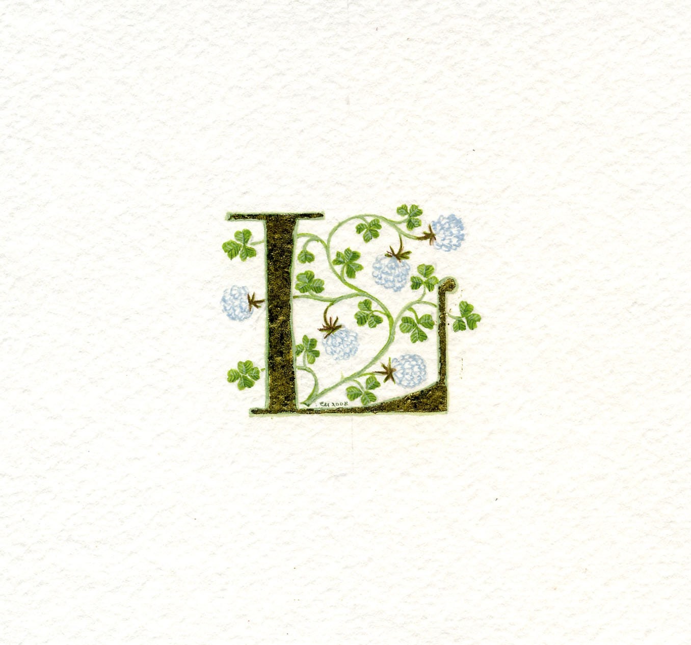 Gold leaf initial letter 'L' with handpainted lucky white clover