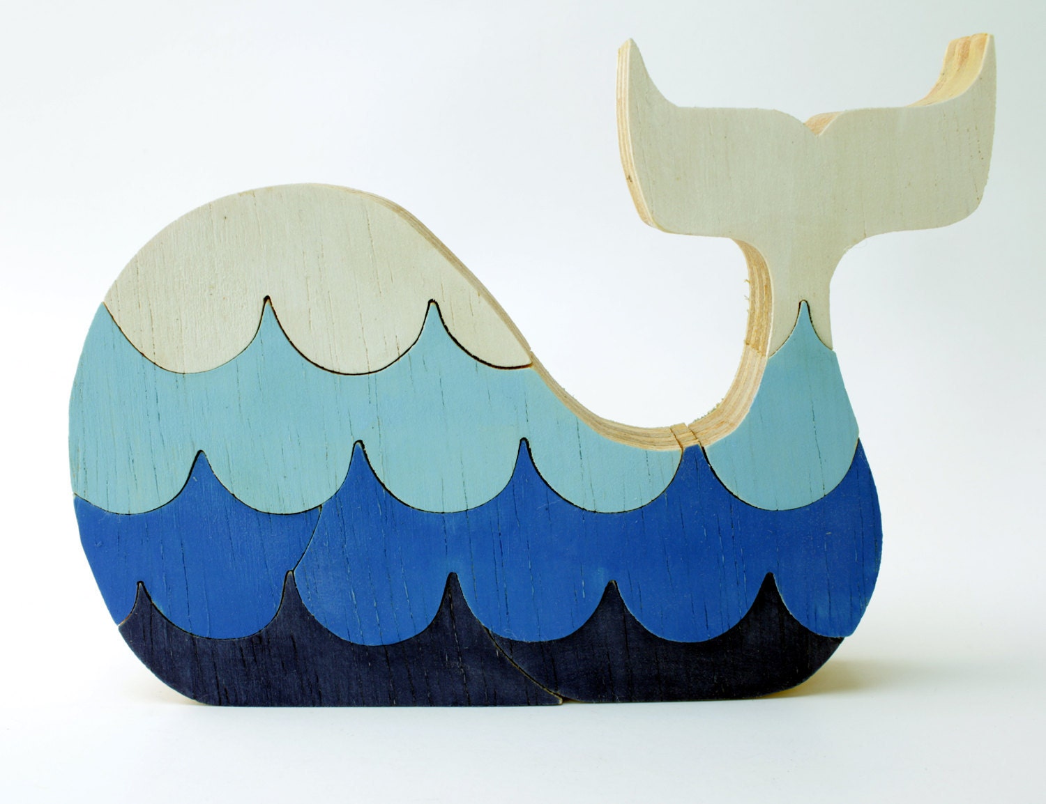 Puzzle whale. Children's game, wood toy, wooden puzzle, whale puzzle with waves.