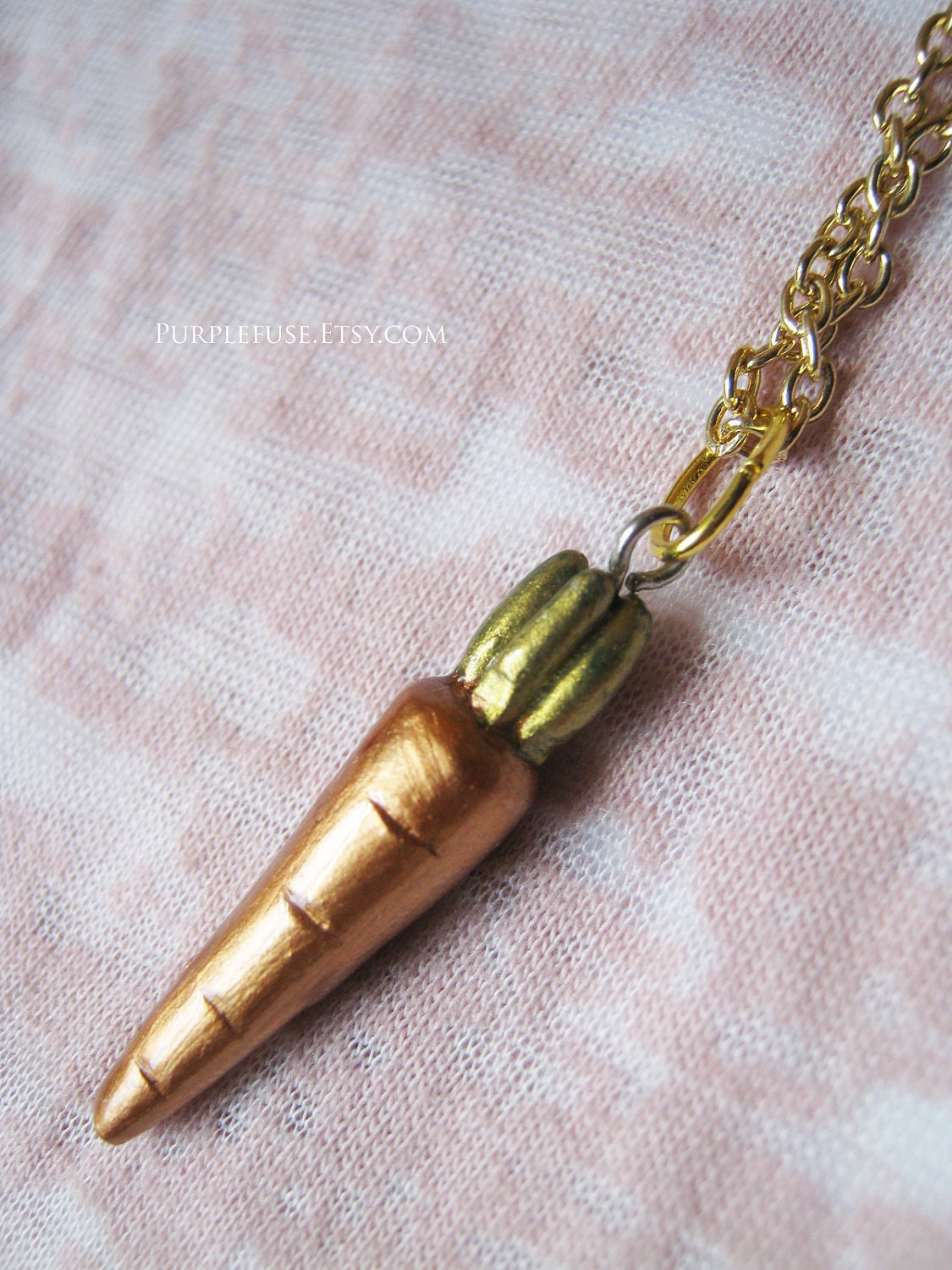 Metallic glossy carrot on golden necklace chain