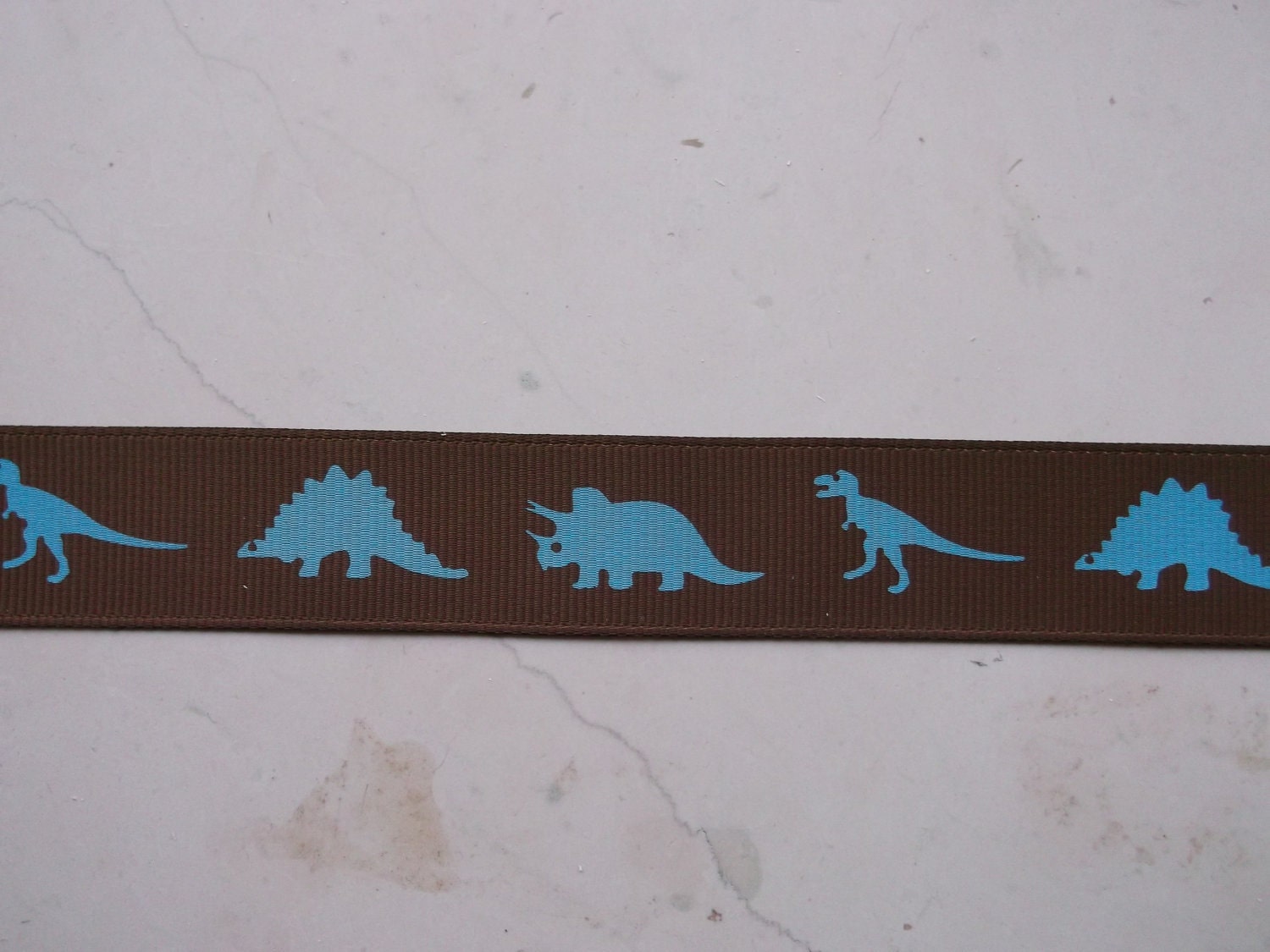Turquoise Dinosaurs Silhouettes on brown 7/8 inch grosgrain ribbon Il_570xn