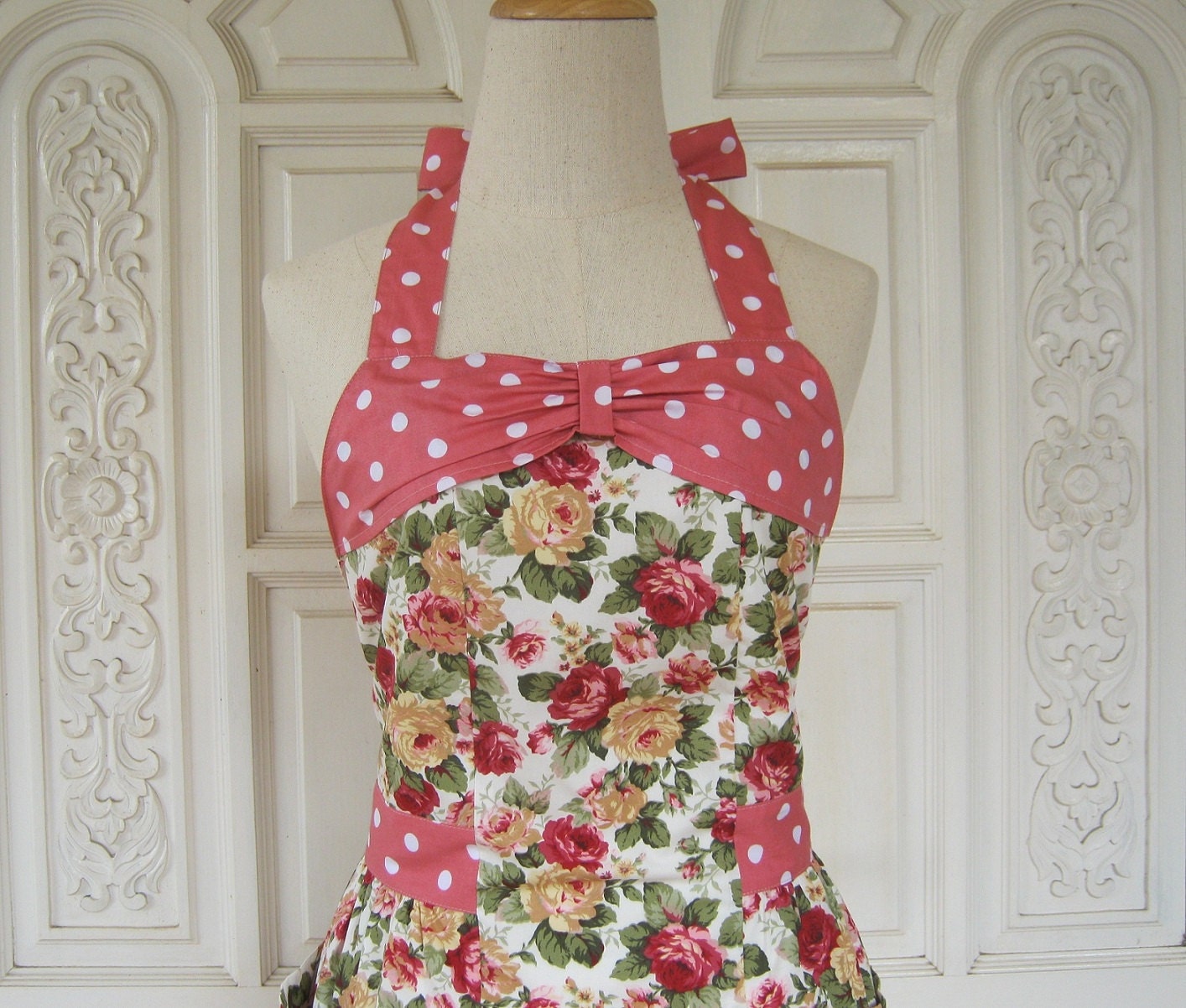 Retro apron with bow, red and yellow rose pattern on white fabric, with white dots on a pink background, fully lined.