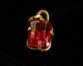 Ruby step cut pendant in brass.