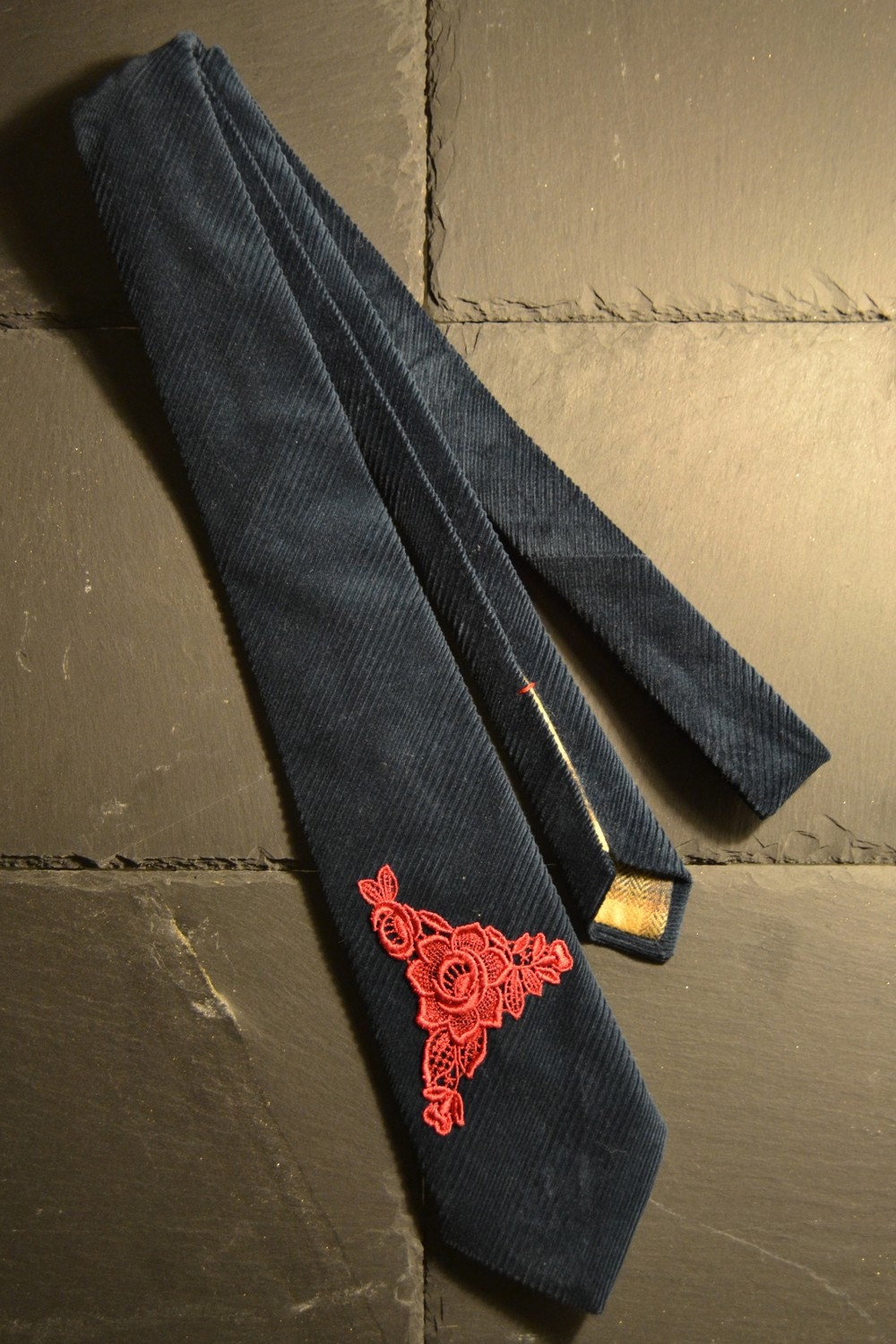 Dark cerulean corduroy necktie with a red embroidery rose adornment