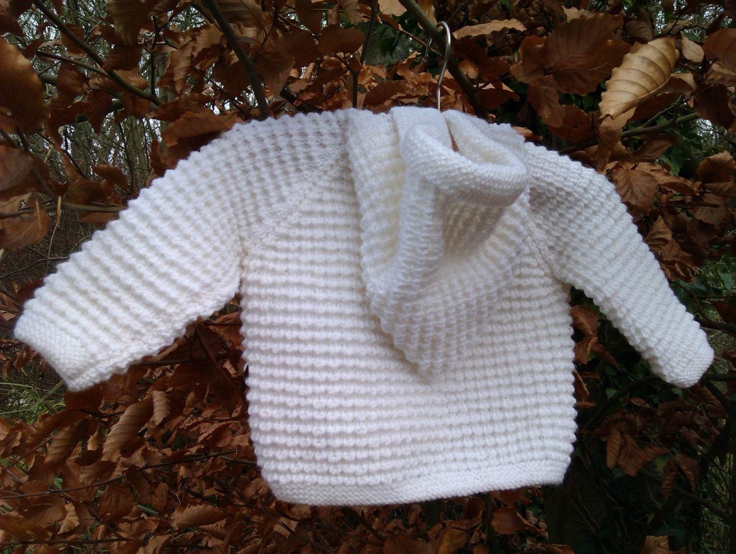 Baby's white jacket with pixie hood and mittens