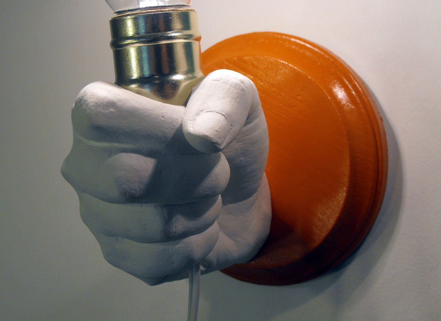 Hand Holding Bulb Wall Lamp (Orange)