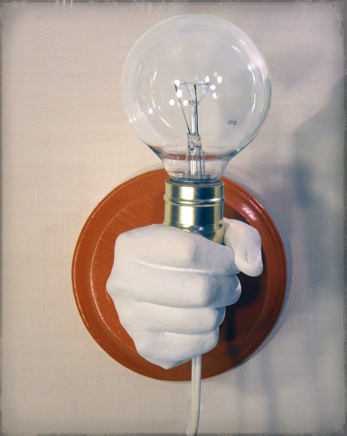 Hand Holding Bulb Wall Lamp (Orange)