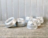 Two Sets of Midcentury stacking dessert molds. Set of 4 swirled aluminum Jell-o style molds and Set of 6 round aluminum aspic style molds