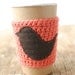 Cup cozy Orange with a bird on it by The Cozy Project