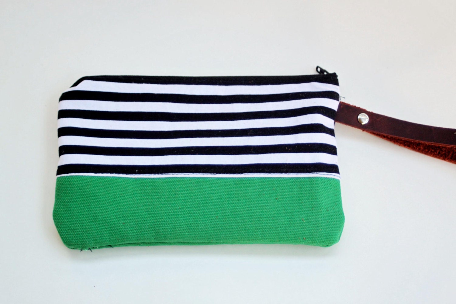 wristlet clutch in black and white strip with green bottom