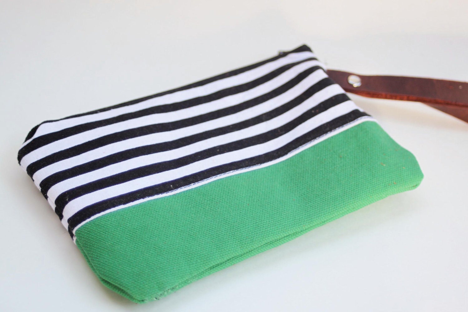 wristlet clutch in black and white strip with green bottom
