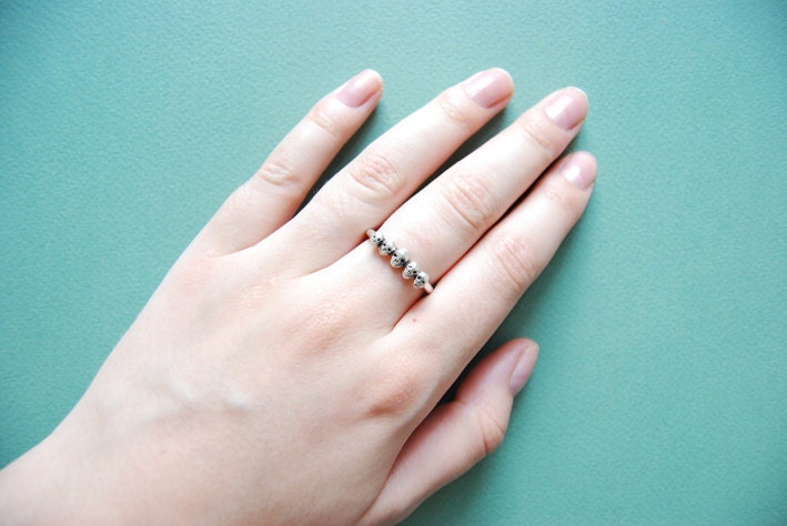 Golden row of tiny skulls ring