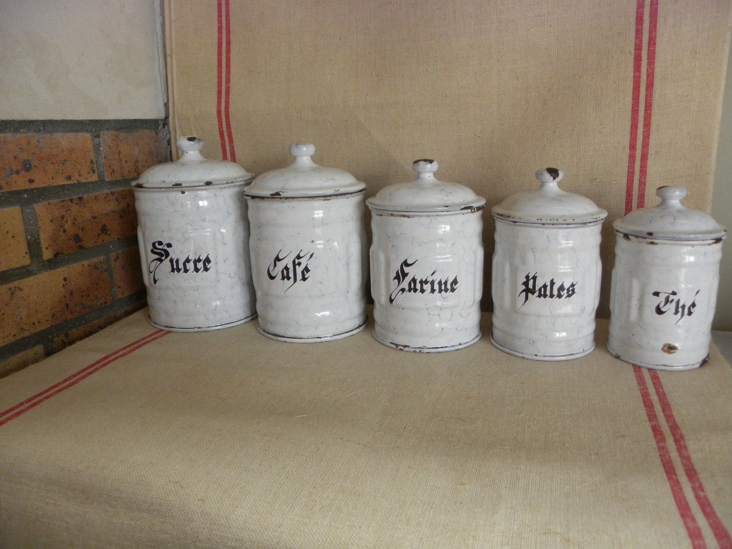 A serie of french white vintage enamel kitchen canisters. Cheaper shipping price in two parcels