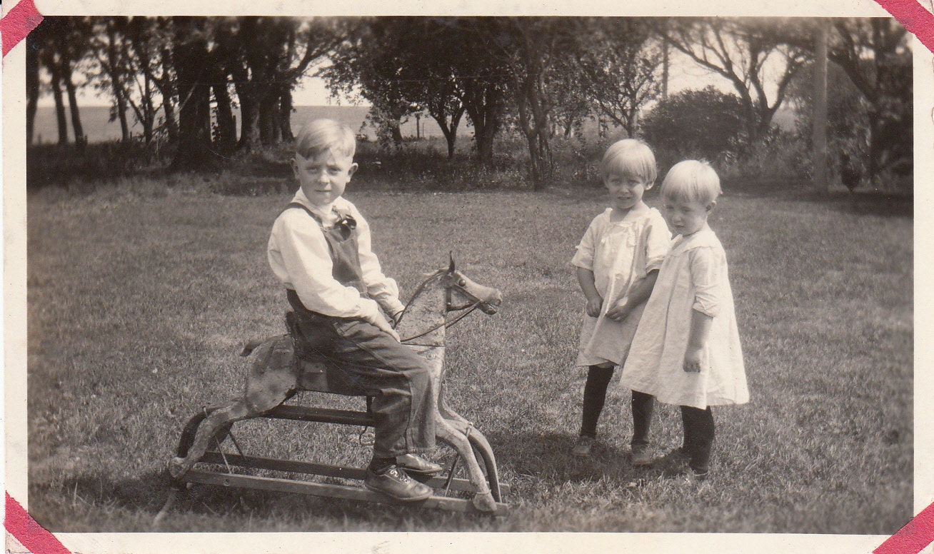 Vintage/ Antique photo of a boy riding his wooden horse and two adorable girls