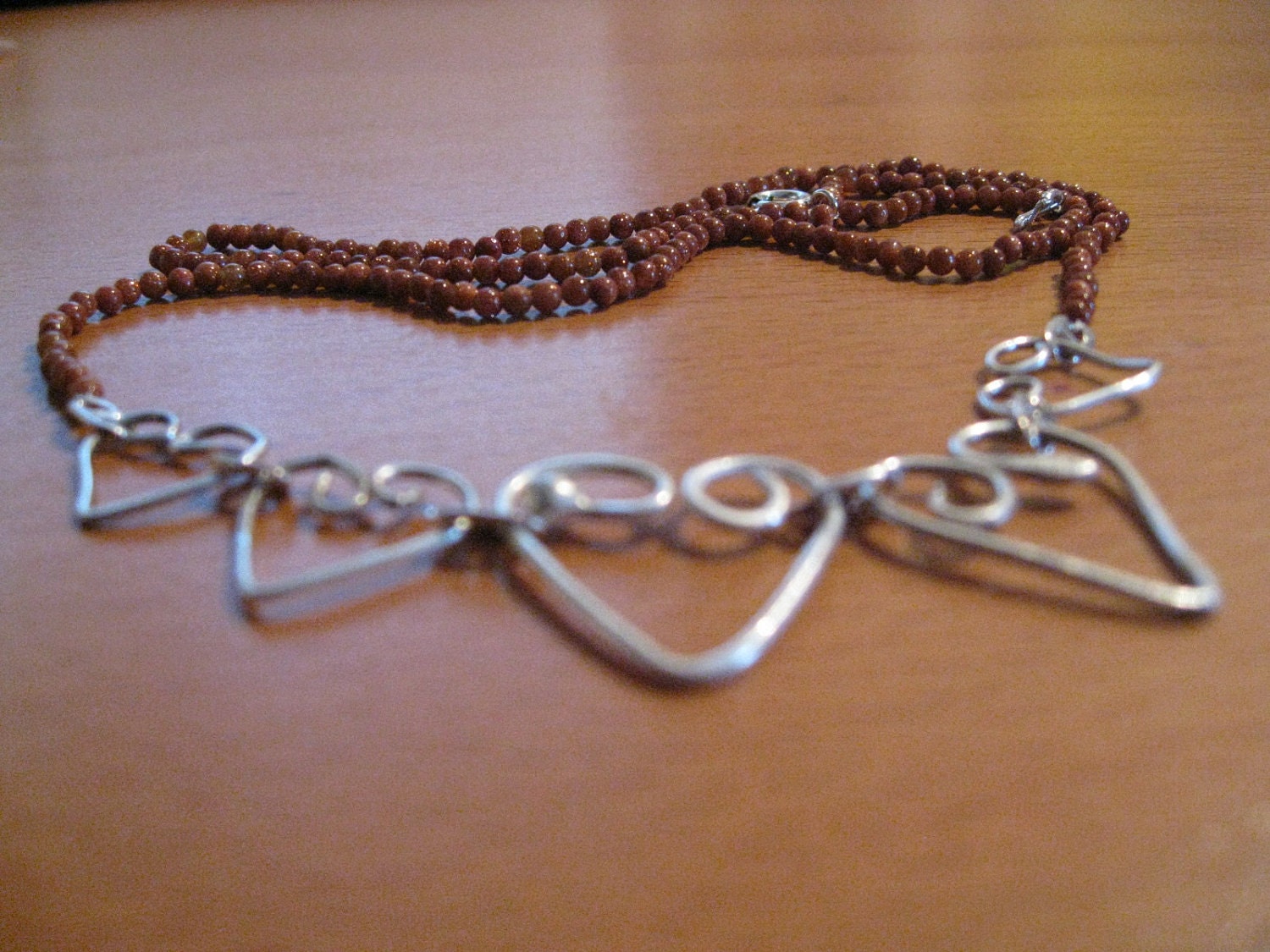 A heart of Five, necklace with goldstone-gemstones and fine silver