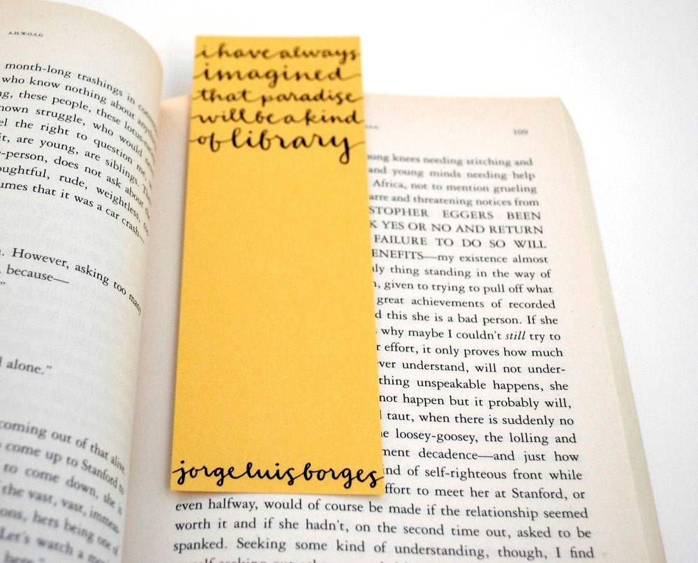Yellow Bookmark with Handwritten Calligraphy . I Have Always Imagined That Paradise Will Be a Kind of Library