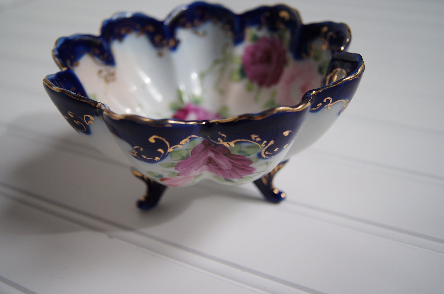 Cobalt blue footed bowl with scalloped edges, hand painted roses and gold detailing