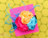 Beautifully bright flower trio with feather accents.  Custom color options available.