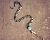 seaya.  a single long arrow and chain earring.