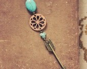 baswell.  a long turquoise wood and arrow necklace.