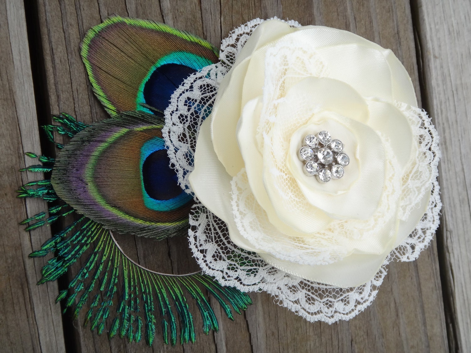 Bridal ivory satin lace flower hair clip accented with a rhinestone, peacock eye and sward feathers