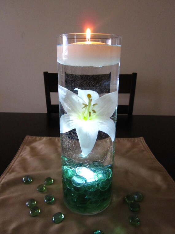 White lily is beautifully suspended in water with sea green marbles.