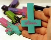 Hand painted wooden cross pin with the word "Slime"