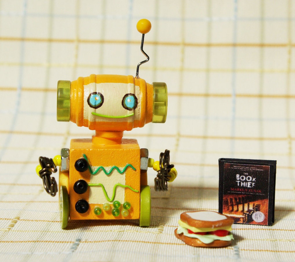 Orange Miniature Wooden Robot with a Book and a Light Snack