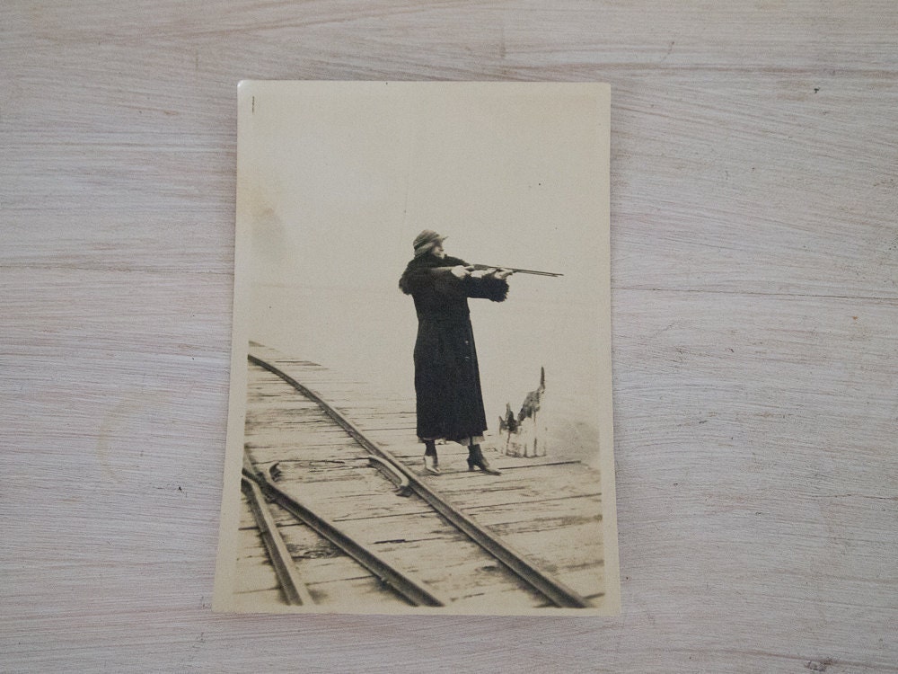 vintage black and white lady in fur on railway with rifle photo from australia