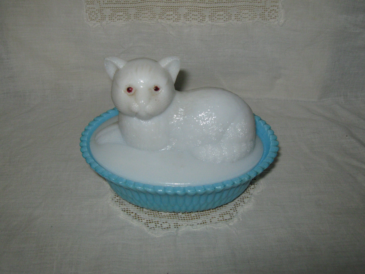 Milk glass cat on blue dish