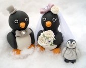 Penguin love birds cake topper with a baby penguin, bouquet with dew drops and a personalized banner
