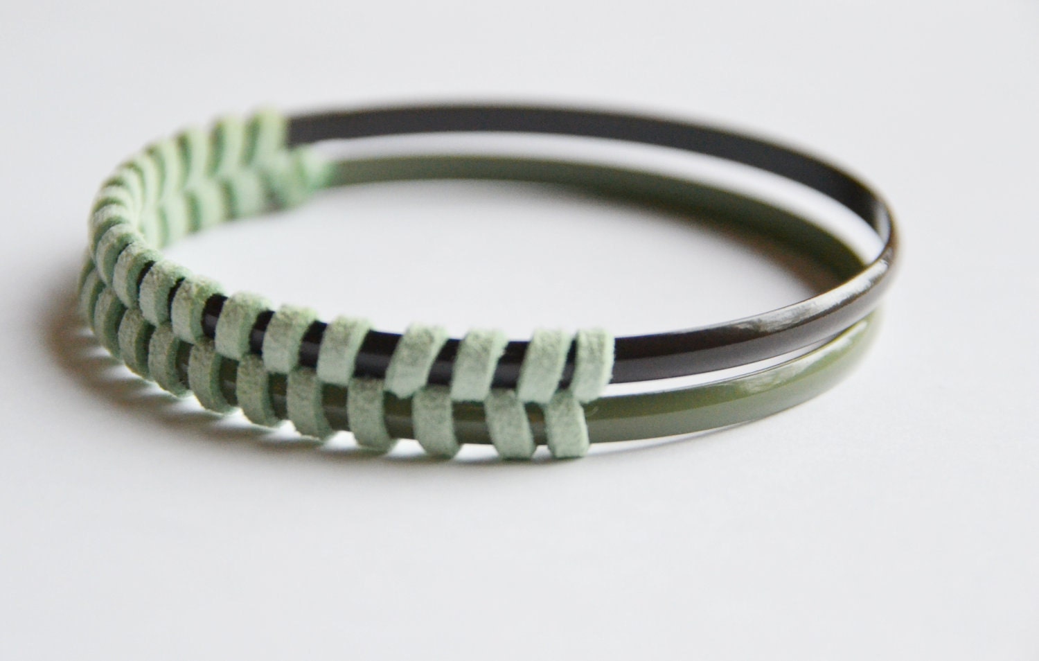 Enamel and suede bangle set. Mint suede, herringbone pattern. One sage bangle, one deep green enamel bangle woven together.