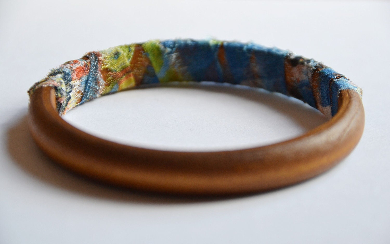Wood and fabric bangle. Summer tribal fabric hand knotted around wooden bangle. Blue/green color. Light weight Small size.