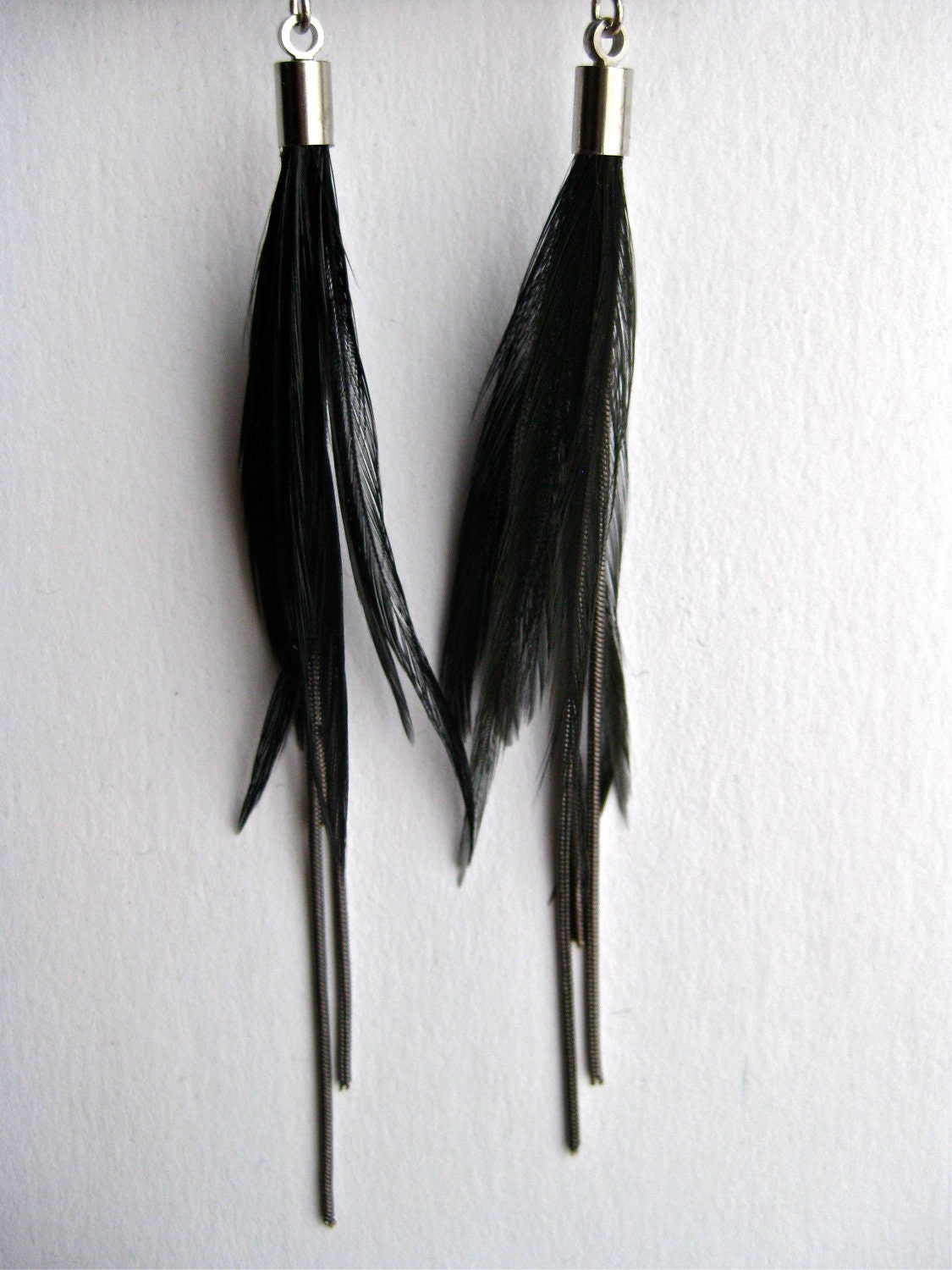 Well balance mixt of chains and feathers earring. Delicate but still an eye catcher. Black chains with Black Rooster feathers, asymmetrical
