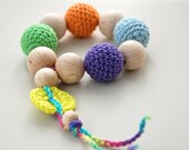 Teething toy with crochet wooden beads. Bright yellow, light blue, orange, green, violet.