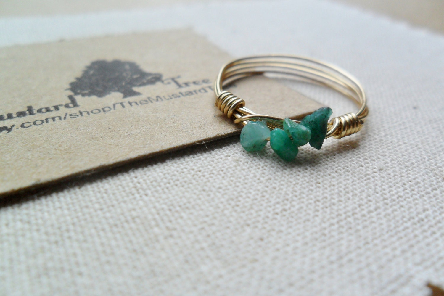 Row of small green rough emerald gemstone chips gold wire wrapped ring