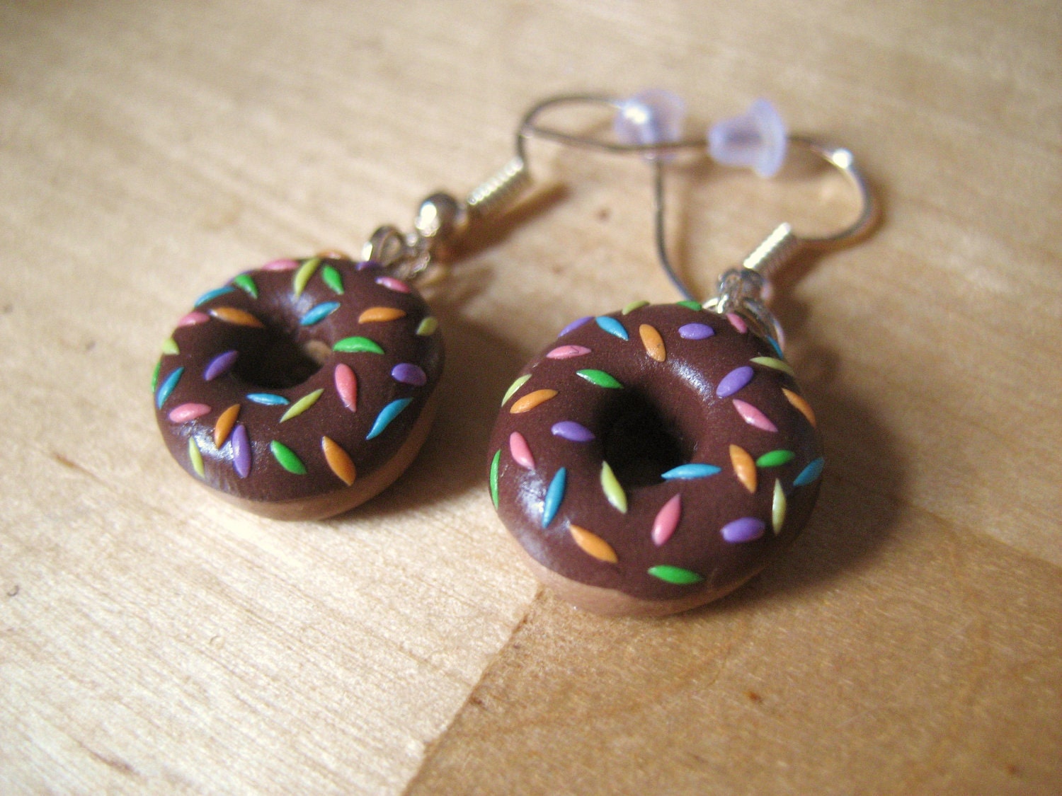 Rainbow-sprinkled donut earrings made from polymer clay