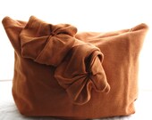 Rust clutch purse or cosmetic bag with two oversized rosettes, contrasting lining and hidden zipper.