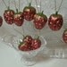 Set of 10 Strawberry ornaments made from a walnut painted with metallic paint to give a glass ornament look Use on tree or gift wrap package