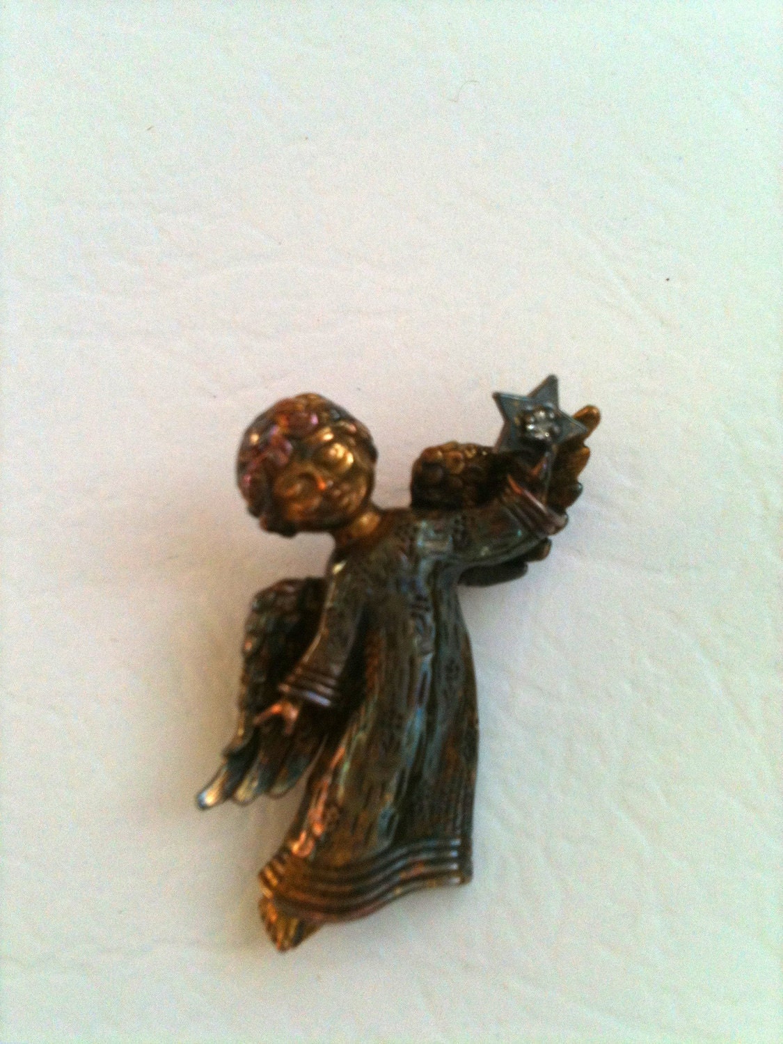 Gold and Antique gold brooch. Angel holding star with small diamond or gemstone. Signed copyrightFM1979.