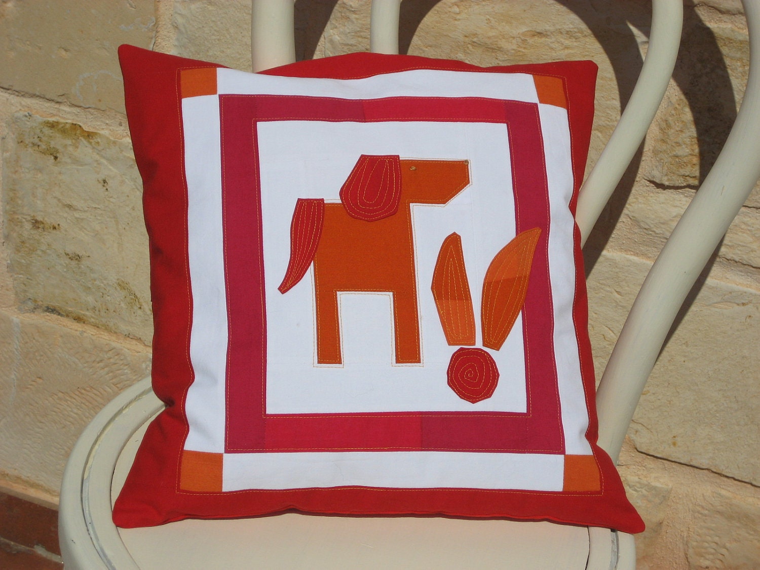 Cushion cover with patchwork and applique dog in red, orange and white
