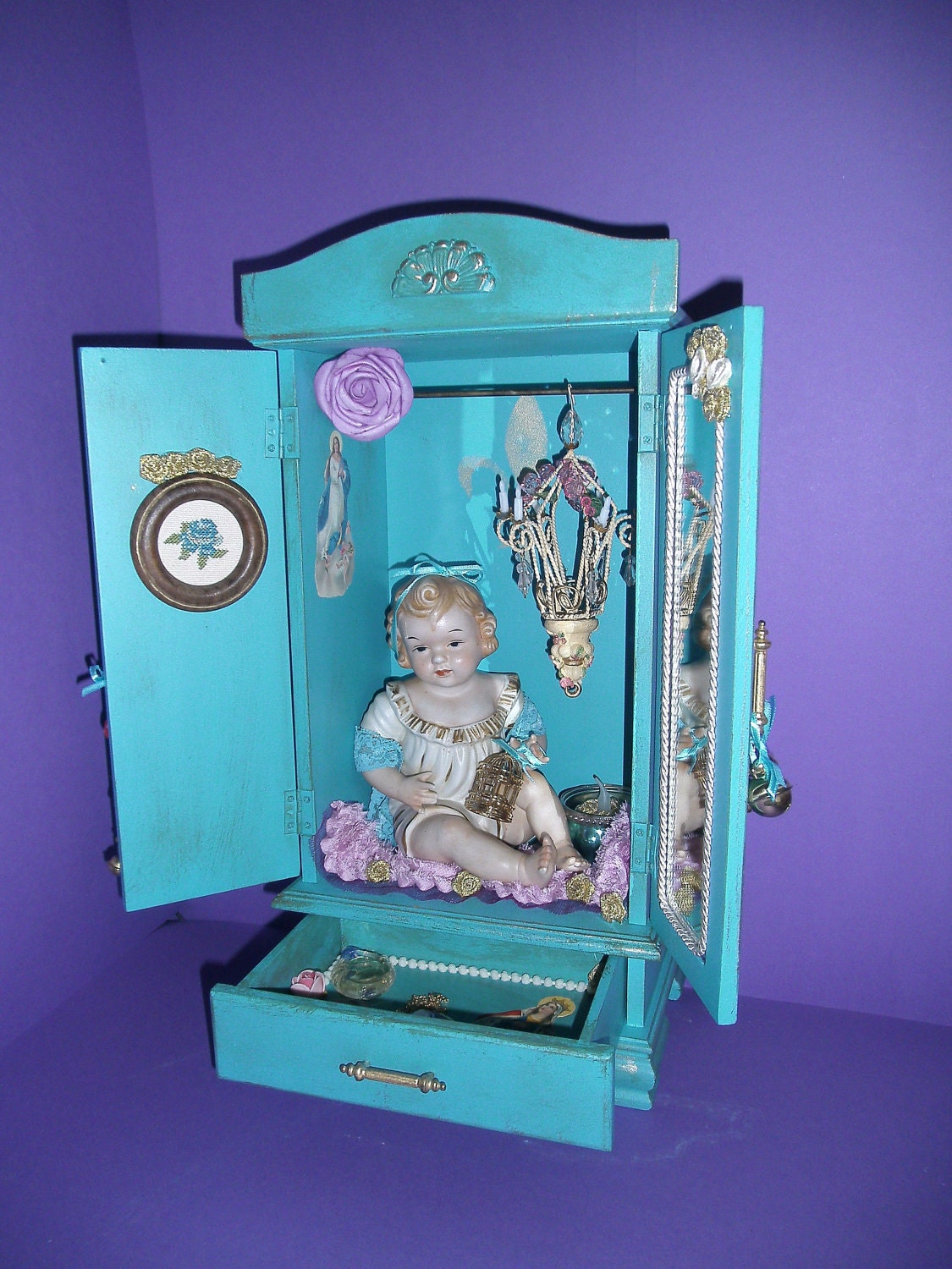 Barbara in a turquoise cabinet with a chandelier too too cute.