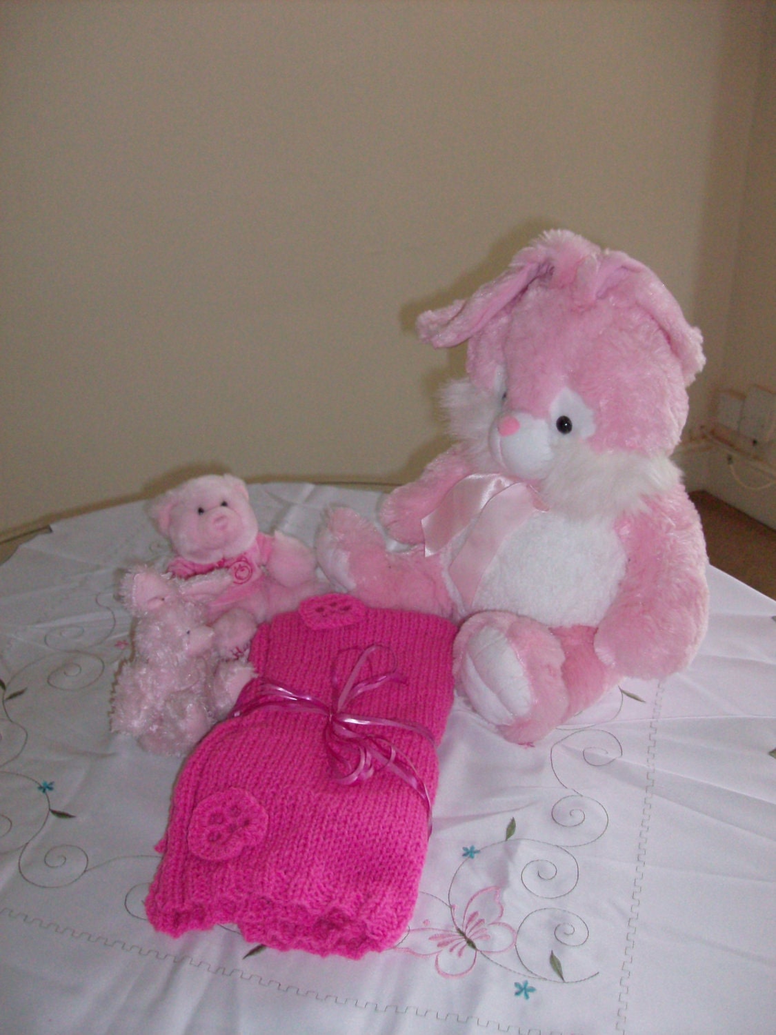 Soft, hand knitted pink baby blanket with crochet flowers
