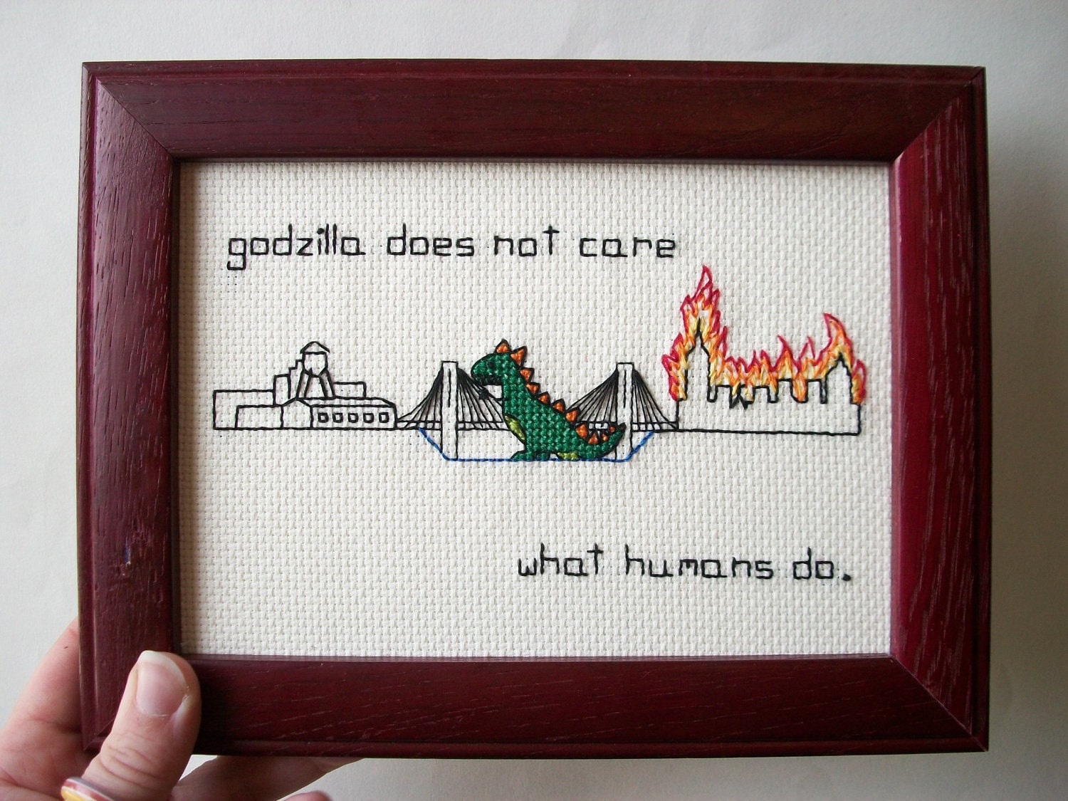 Godzilla burning down NYC -- and not even caring. Godzilla between Manhattan and Brooklyn, burning borough of your choice..